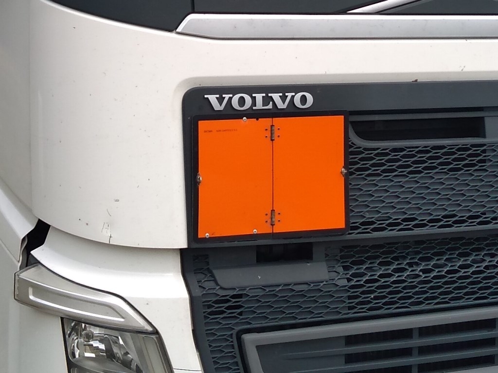 Ciężarówka oznakowana pomarańczową tablicą informującą o przewozie towarów niebezpiecznych.